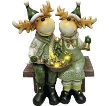 Des figurines décoratives d''élans avec éclairage LED et motifs de Noël sont assises sur un banc.