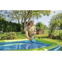 Mann benutzt eine Tauchpumpe, um Wasser aus einem Schwimmbecken im Garten abzupumpen.