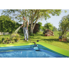 Szene eines Mannes, der einen Pool mit einem Gartenschlauch füllt.