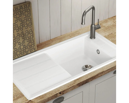 Évier blanc avec égouttoir et robinet sur un plan de travail