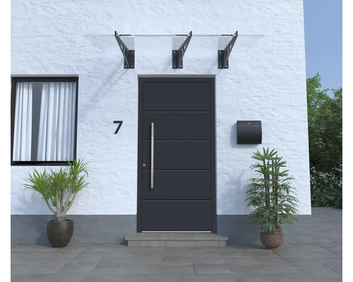 Porte d''entrée avec auvent, boîte aux lettres et plantes en pot devant une façade de maison