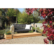 Gartenlandschaft mit Holzterrasse, Gartenbank mit Kissen und bepflanztem Blumenkasten