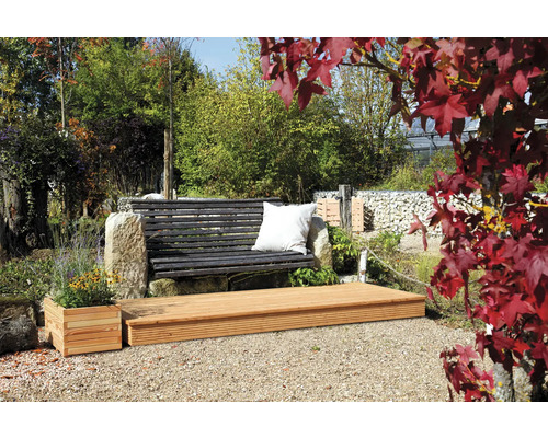 Gartenlandschaft mit Holzterrasse, Gartenbank mit Kissen und bepflanztem Blumenkasten