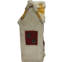 Maison décorative en céramique avec de la neige sur le toit et une cheminée.