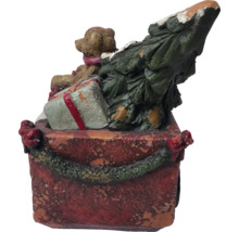 Dekorative Weihnachtsszene mit Teddybär, Geschenk und Weihnachtsbaum auf einer roten Basis