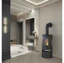 Elegantes Interieur mit Kaminofen, Spiegel und Sitzhocker in einem hellen Raum.