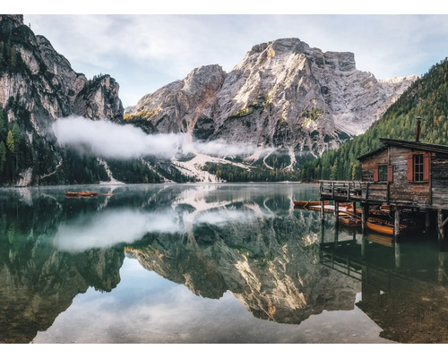Bergsee mit Holzhaus und Berggipfeln
