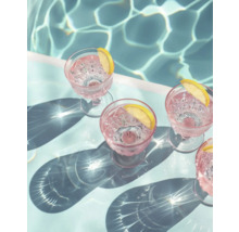 Scène avec verres, boissons et tranches de citron à côté d''une piscine