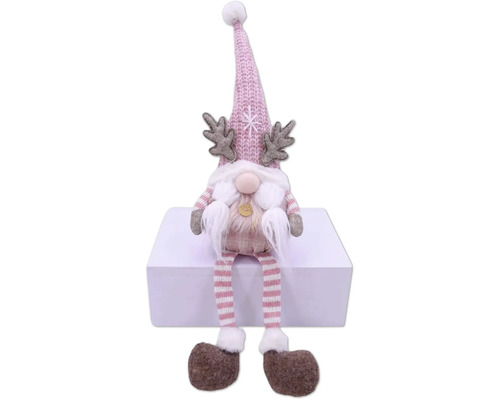 Nain de Noël décoratif avec bonnet, bois de cerf et jambes rayées assis sur une surface blanche