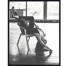 Schwarzweißfoto einer Frau, die verkehrt herum auf einem Stuhl sitzt