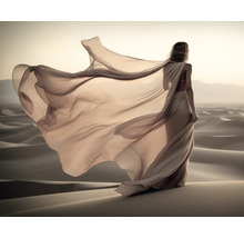 Une femme avec une robe fluide se tient dans un désert.
