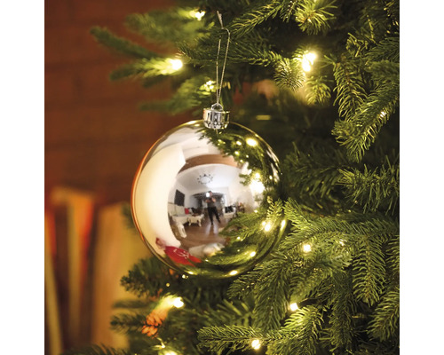 Christbaumkugel an einem Weihnachtsbaum mit Beleuchtung