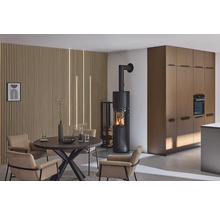 Espace de vie avec poêle à bois, table à manger et chaises devant un mur en lambris