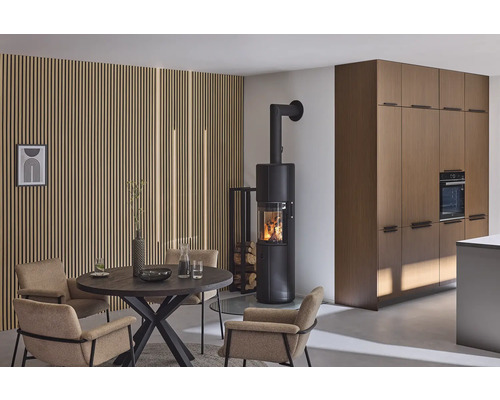 Espace de vie avec poêle à bois, table à manger et chaises devant un mur en lambris