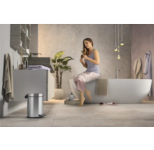 Modernes Badezimmer mit freistehender Badewanne, Waschtisch und Treteimer aus Metall.
