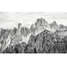 Photographie en noir et blanc d'un paysage de montagne avec des formations rocheuses accidentées et un ciel nuageux