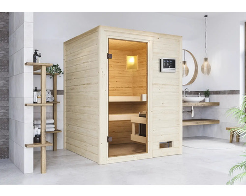 Massivholzsauna Karibu Sandra inkl.9 kW Ofen u.ext.Steuerung ohne Dachkranz mit bronzierter Ganzglastüre Helle Holzsauna mit Glastür und Bedienelement in einem Badezimmer mit Waschbecken und Regal.