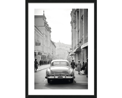 Schwarzweißfotografie mit Oldtimer in einer Stadtstraße, gerahmt