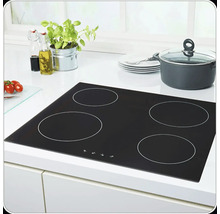 Table de cuisson noire avec quatre zones de cuisson dans un environnement de cuisine