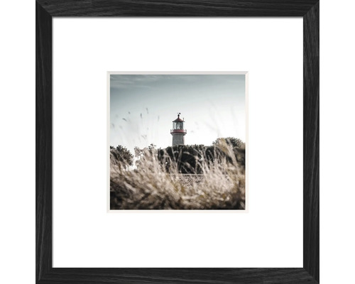 Gerahmtes Bild eines Leuchtturms hinter Gras
