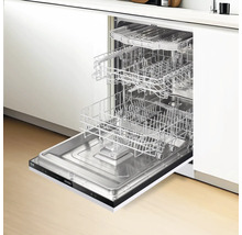 Lave-vaisselle ouvert avec plusieurs paniers à vaisselle dans une cuisine moderne