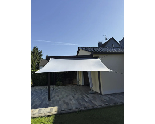 Voile d'ombrage au-dessus d'une terrasse avec sol en pierre