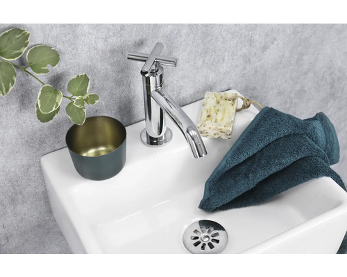 Modernes Waschbecken mit Armatur, Seife, Handtuch und Becher