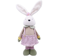 Lapin en peluche avec une salopette et une fleur sur la tête
