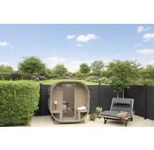 Gartenansicht mit Fasssauna, Liegestuhl und Zaun vor Rasenfläche