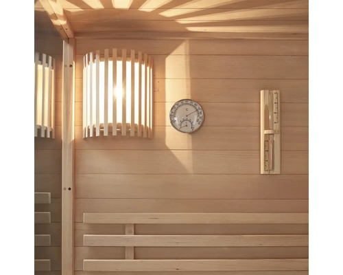 Innenansicht einer Sauna mit Holzverkleidung, Lampe, Thermometer und Hygrometer.