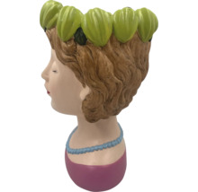 Pot de fleurs en forme de tête de femme avec décor floral