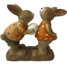 Décoration de Pâques avec deux figurines de lapins, dont l'une offre un œuf de Pâques à l'autre