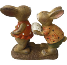 Figurines de lapins décoratives sur un socle, une figurine tient un œuf