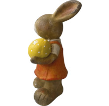 Figurine de lapin décorative tenant un œuf orné dans ses bras.