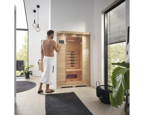 Mann bedient eine Home Deluxe Infrarotsauna in einem Badezimmer