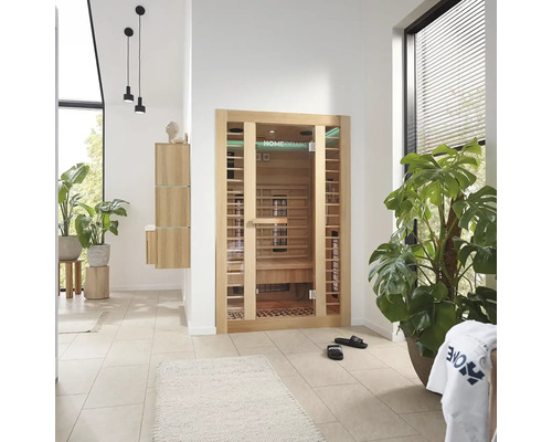 Heller Raum mit Home Deluxe Sauna, Pflanzen und Badezimmermöbeln.