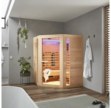 Eckige Infrarotsauna aus Holz in einem Badezimmer mit Badewanne, Handtüchern und Pflanzen.
