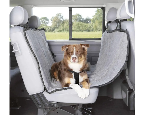 Chien allongé sur une housse de siège auto à l'intérieur du véhicule