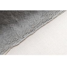 Gros plan d'une couverture douce grise avec un dessous blanc.