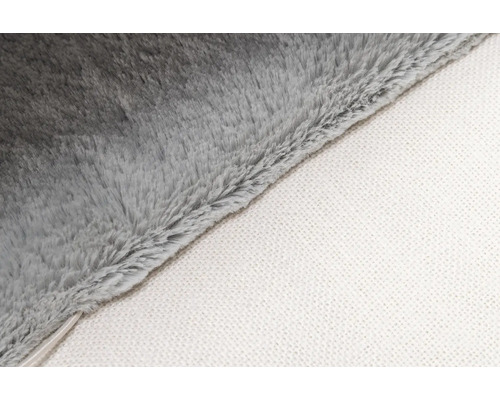 Gros plan d'une couverture douce grise avec un dessous blanc.