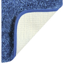 Detailansicht eines blauen Teppichs mit gewendeter Ecke, die die Rückseite zeigt