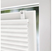 Vue détaillée d'un store plissé blanc sur une fenêtre