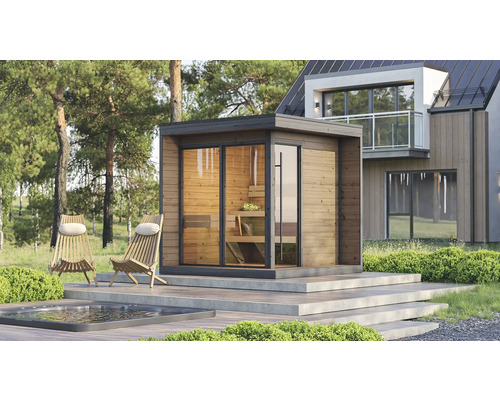 Helle moderne Aussensauna mit Holzfassade und Glaswänden auf einer Terrasse neben einem Pool und Liegestühlen vor einem modernen Haus im Wald.