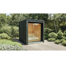 Moderne Gartensauna in Würfelform mit dunkler Holzfassade und großer Glasfront auf einer Holzterrasse im Garten.