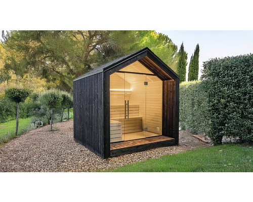 Sauna de jardin moderne avec façade en bois sombre, intérieur en bois clair, grande façade vitrée et toit à deux pans dans un jardin.