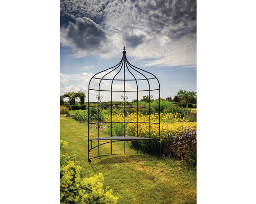 Banc de jardin avec treillis en métal dans un jardin fleuri