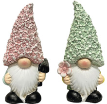 Zwei Gartenzwerge mit Blumenhut, einer mit Schaufel, einer mit Blume