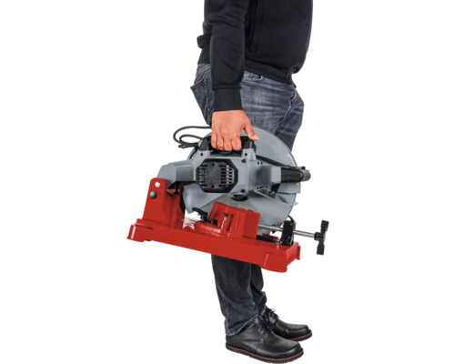 Une personne tient une scie à métaux avec une base rouge.