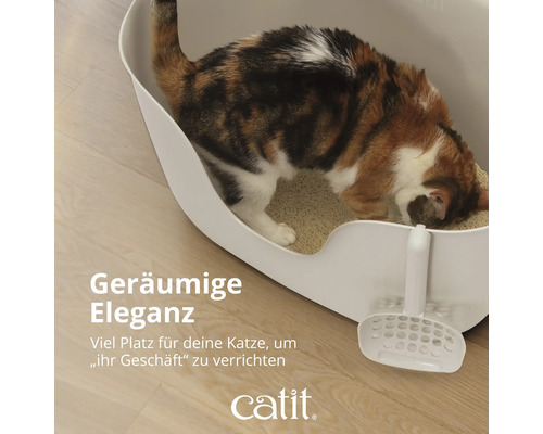 Katze in einer weißen Katzentoilette mit Schaufel