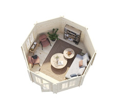 Vue intérieure d'un abri de jardin avec des meubles, dont un canapé, des fauteuils, des étagères et des tables